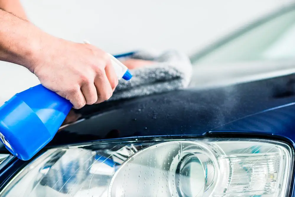 Man cleaning car with car care products